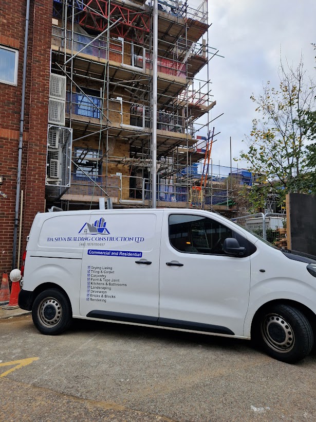 The Da Silva Building Construction branded van on site in front of a scaffolded building